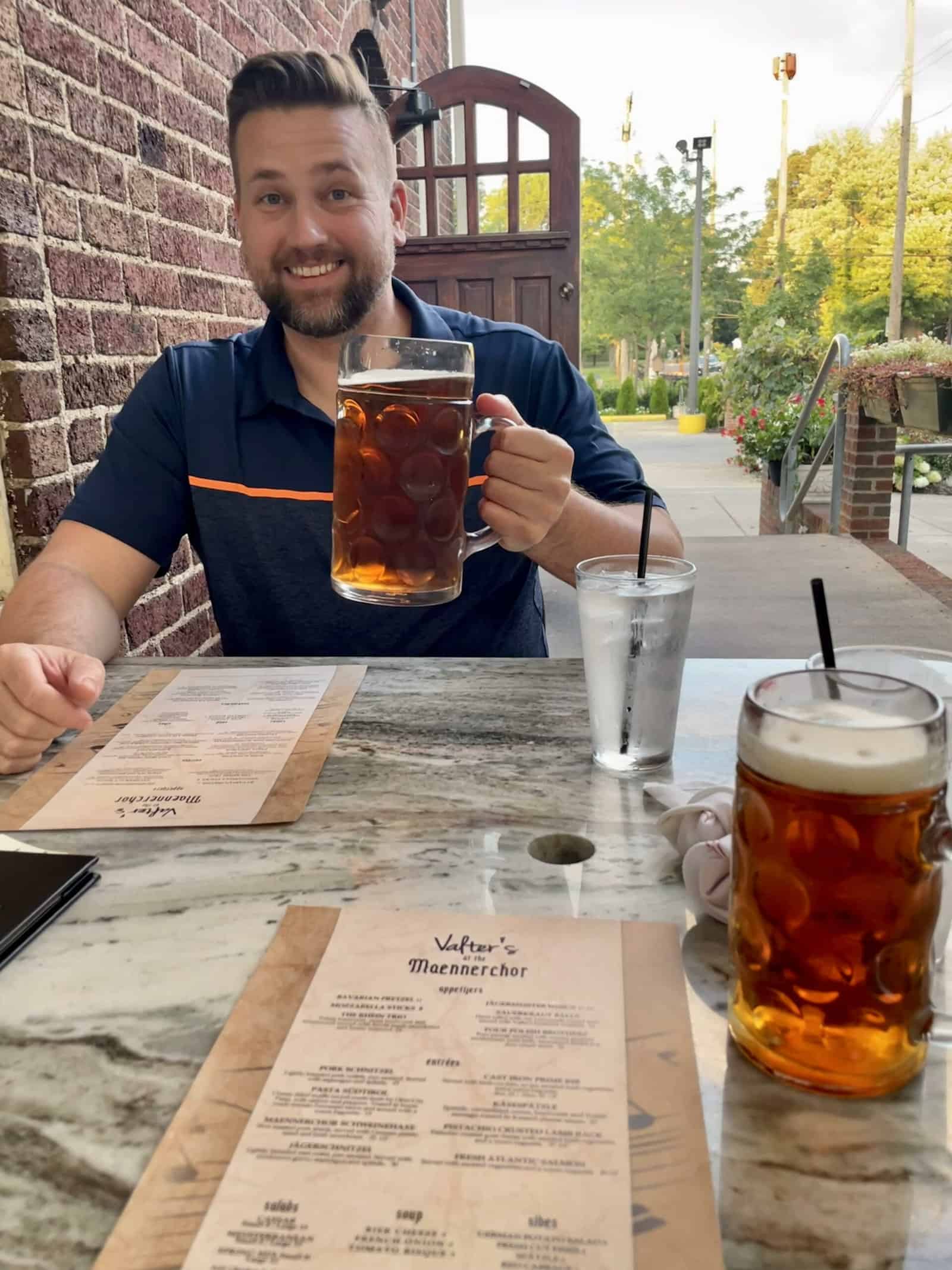 Matt Cochrell holding a large pint of German beer at Valter's at the Maennerchor
