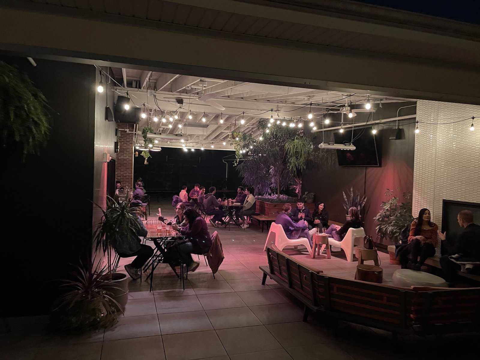 Guests at tables on a lively rooftop bar patio in German Village
