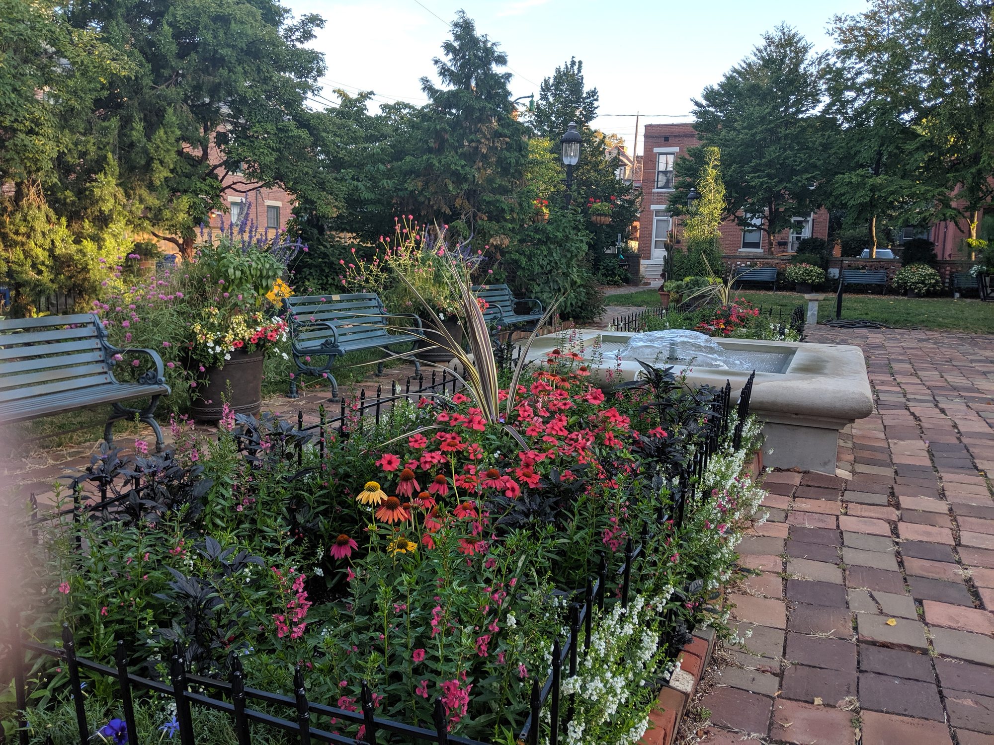 Fountain surrounded by summer flowers and park benches at Frank Fetch Park